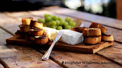 An appetizer of baked brie, grapes and toasted baguette.