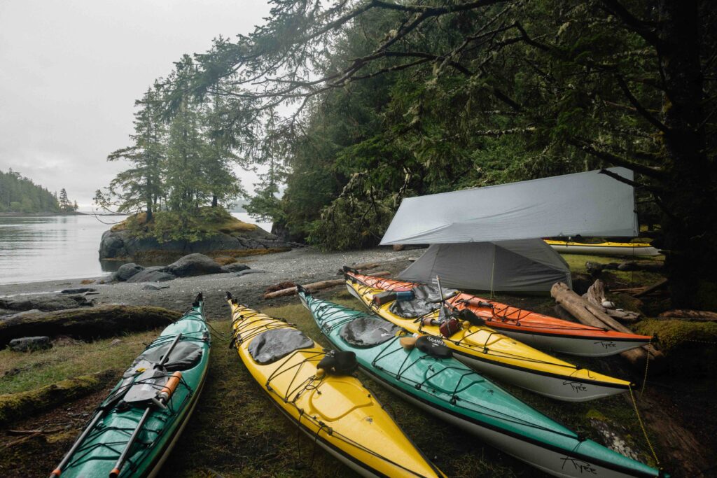 Five kayaks and one tent on a misty day.